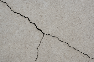 Close-up of a cracked concrete surface indicating deterioration.