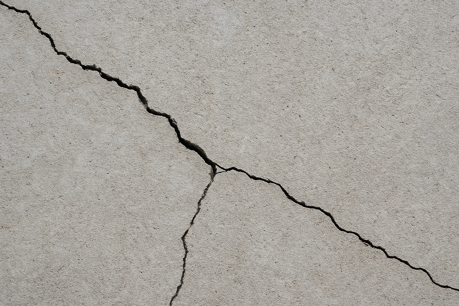 Close-up of a cracked concrete surface indicating deterioration.